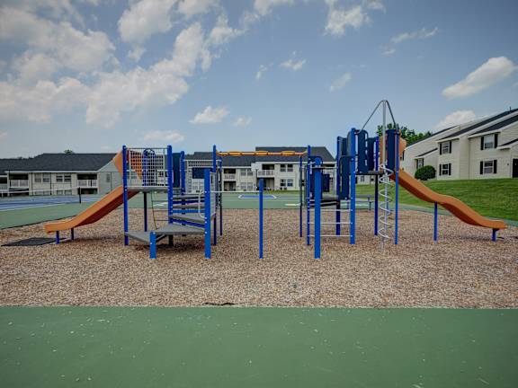 A playground with a blue and orange slide.