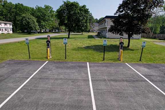 A parking lot with four parking meters.