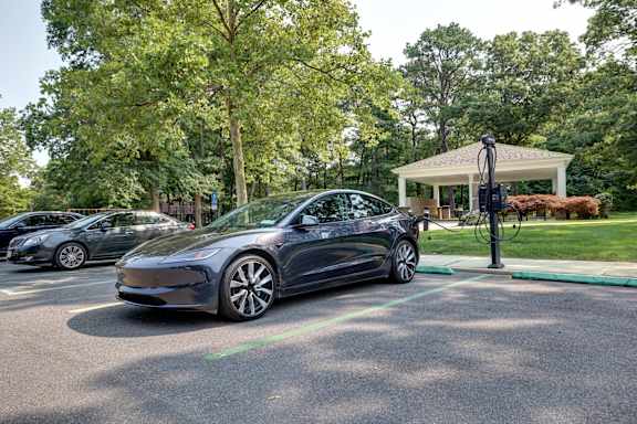 A Tesla car is parked in a parking spot.