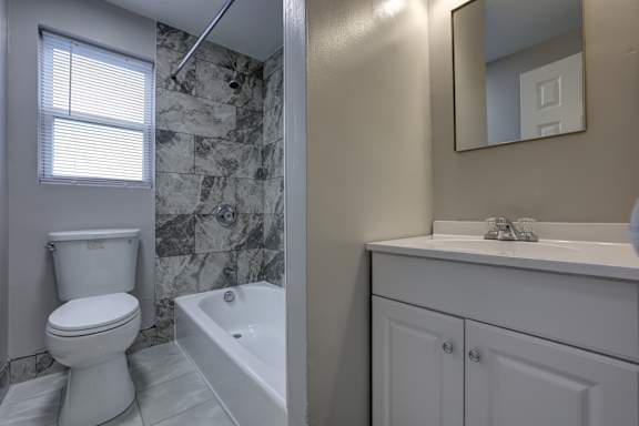 A white toilet sits next to a bathtub in a bathroom.