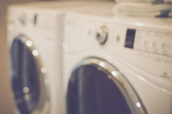 Two front loading washing machines are in a row.