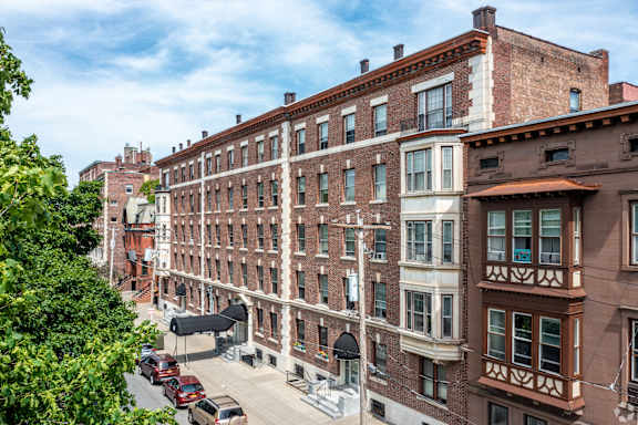 A street view of a city with cars and brown buildings. at Willett Apartments, Albany, 12210