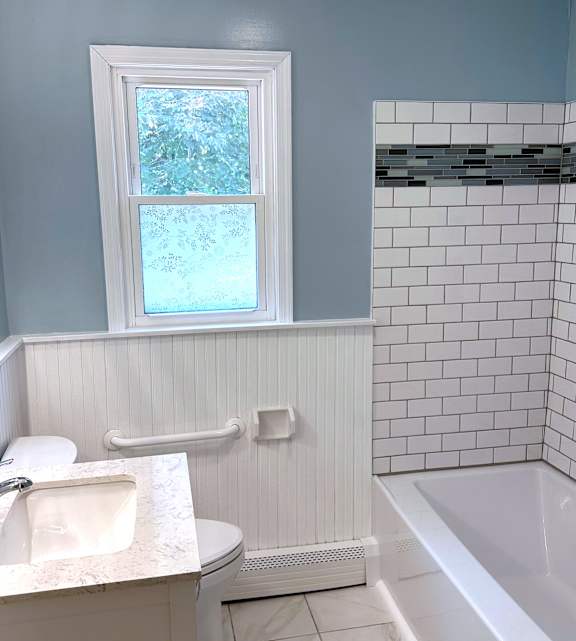 a bathroom with a white toilet next to a bathtub