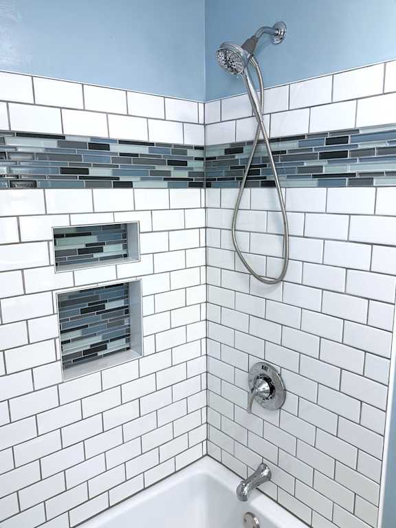 a bathroom with white subway tile and blue walls