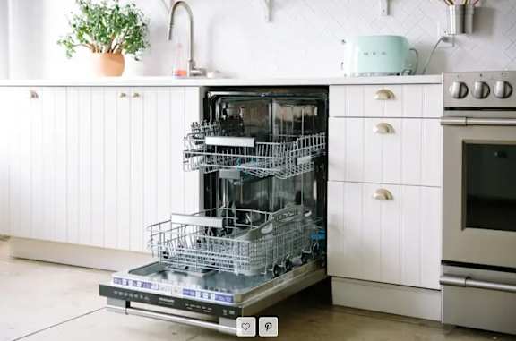 A dishwasher is open and full of dishes in a kitchen.