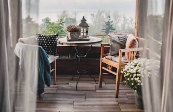 A cozy table setting with a lantern and a cat on a chair.