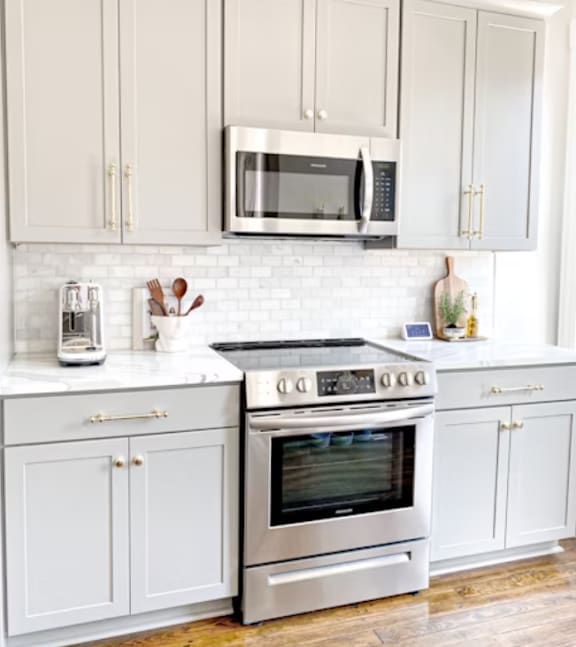 A kitchen with a stove and a microwave above it.
