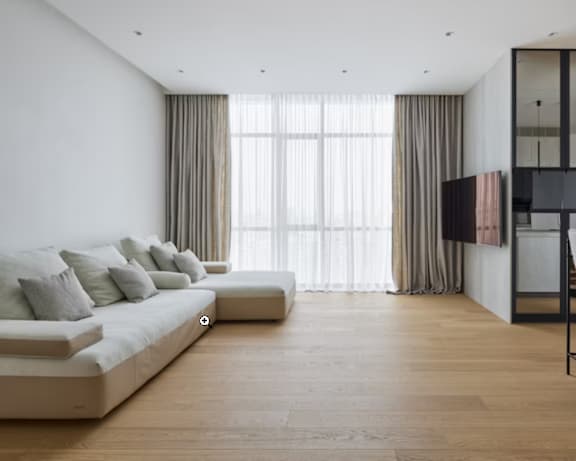 A modern living room with a large window and a white sofa.