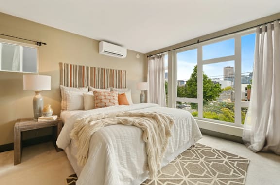 A bedroom with a large bed and a view of the city.