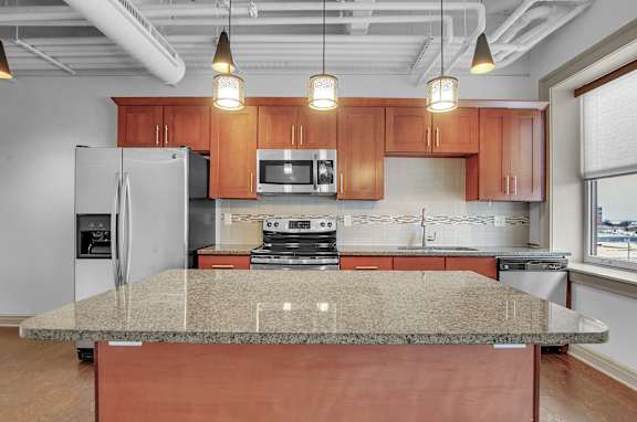 a kitchen with granite counter tops and wooden cabinets