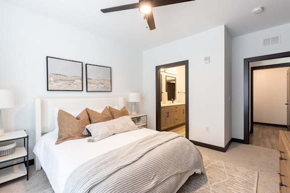 a bedroom with a large bed and a ceiling fan