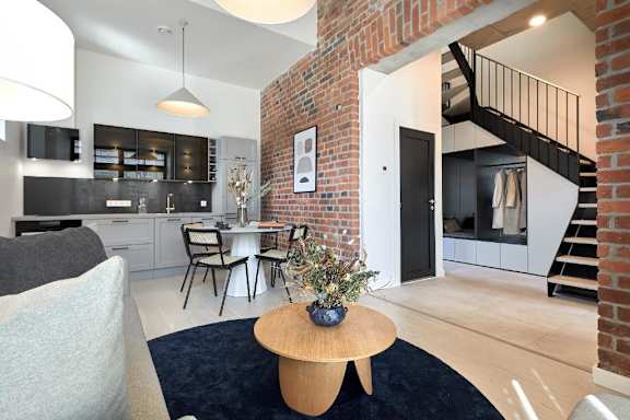 A modern kitchen with a brick wall and a dining area.