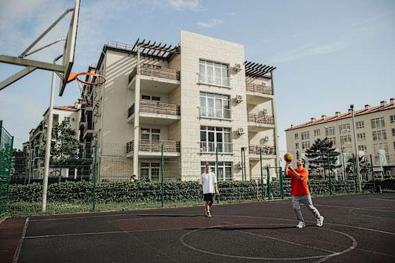 Two men playing basketball on an outdoor court.