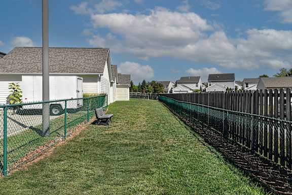 a fenced in yard with a bench next to a fence
