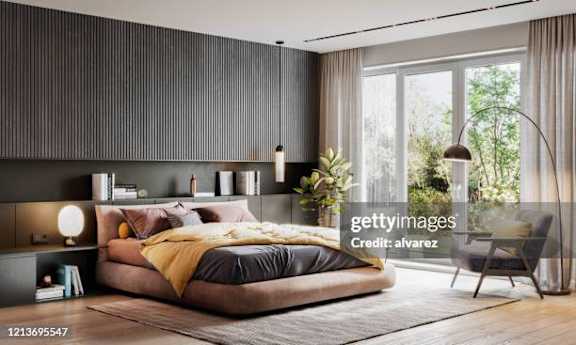A modern bedroom with a large bed and a chair.