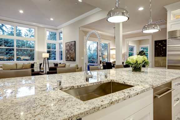 A modern kitchen with granite countertops and a large window.