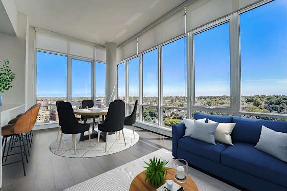 a living room with a view of the city and a blue couch and a table