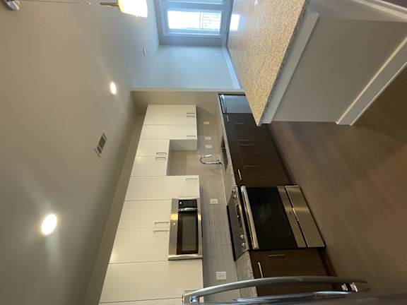 A modern kitchen with stainless steel appliances and a window above the sink.