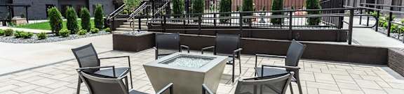 A patio with a table and chairs and a fountain.