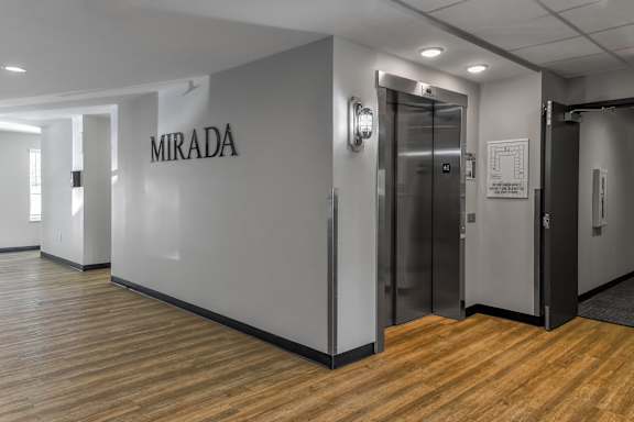 a room with a wall that says mirada and a metal elevator