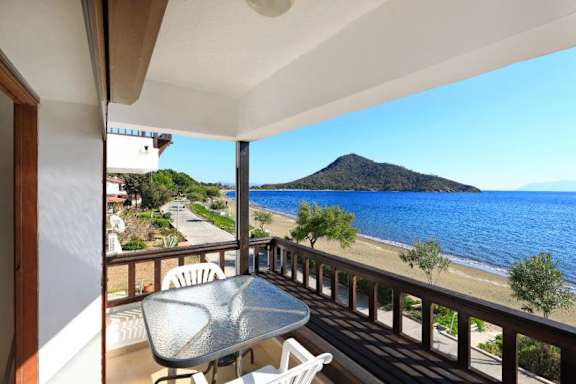a table and chairs on a balcony overlooking the ocean