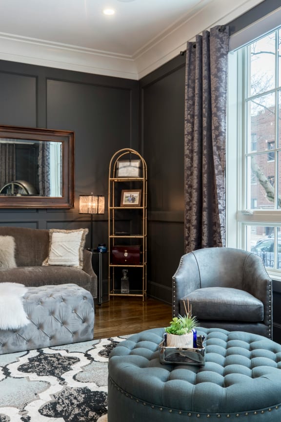 a living room with gray walls and a blue ottoman