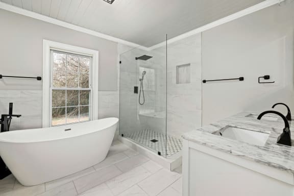 a white bathroom with a tub and a shower
