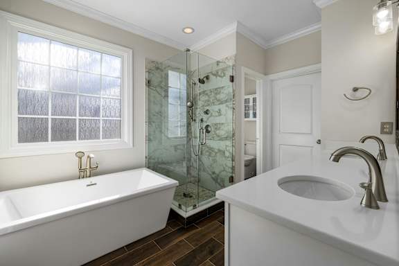 a bathroom with a tub and a shower and a sink