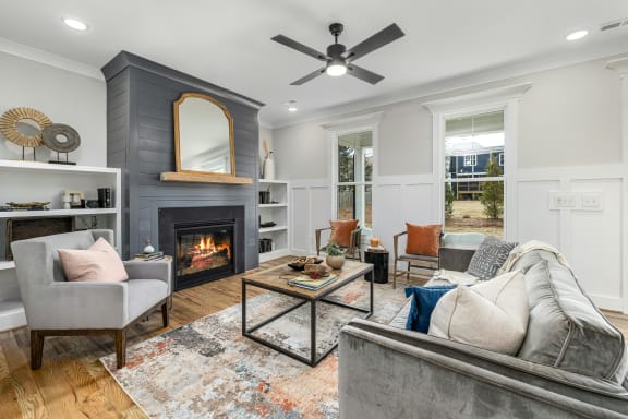 a living room with a fireplace and a ceiling fan