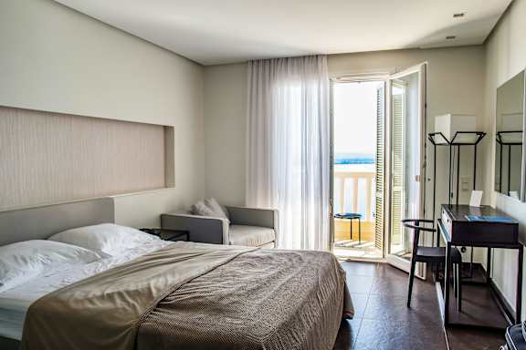 a hotel room with a bed and a door to a balcony