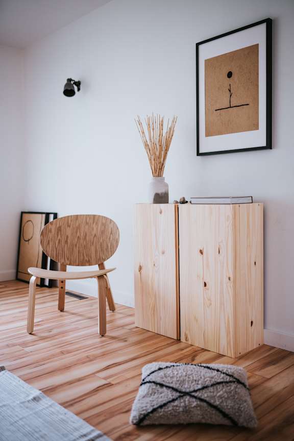 a room with plywood floors and a wooden chair