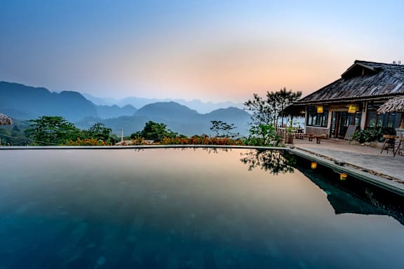 a pool in front of a house with mountains in the background