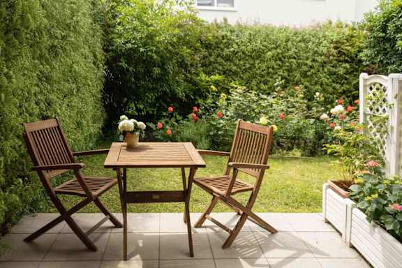 A table and two chairs are set up on a patio.