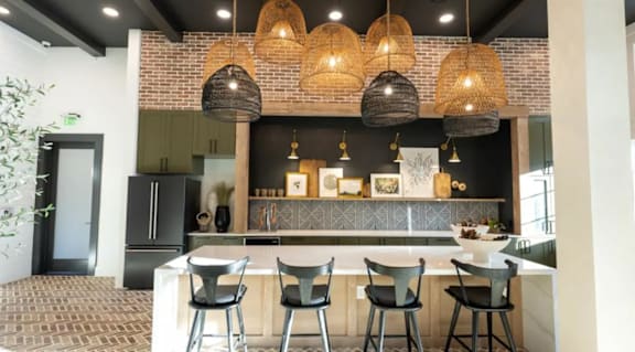 A kitchen with a black and white theme and a bar area with chairs.