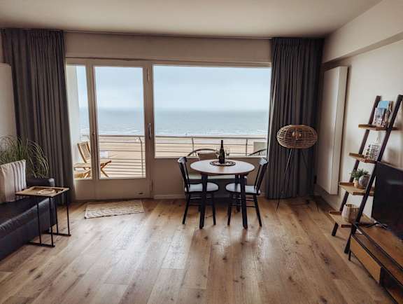 A dining room with a table set for two and a view of the ocean.