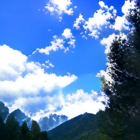 a blue sky with white clouds and a mountain in the background