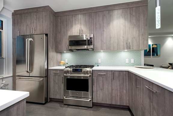 A modern kitchen with a stainless steel refrigerator and oven.