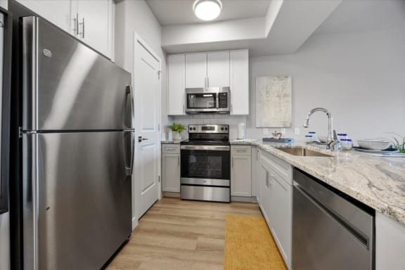 a kitchen with stainless steel appliances and marble counter tops