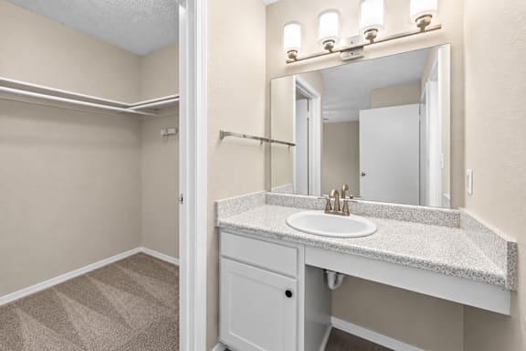 A bathroom with a sink, mirror, and a cabinet.