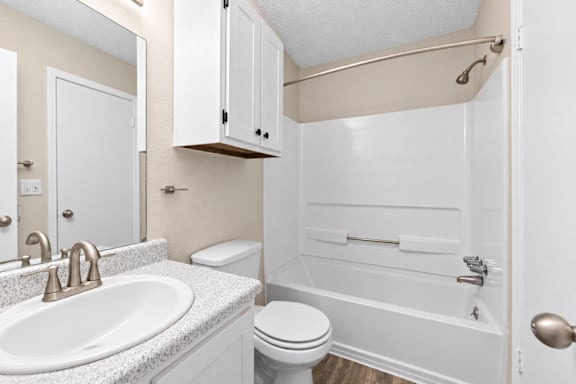 A white bathroom with a sink, toilet, and bathtub.