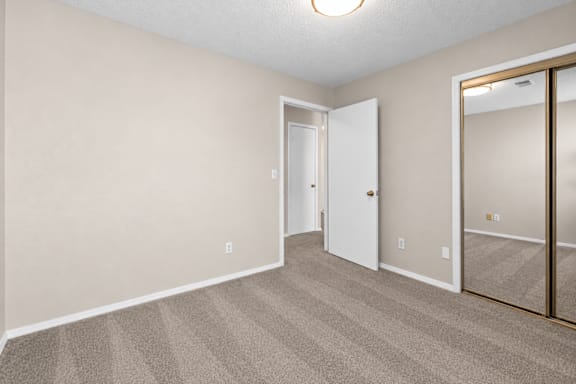 A room with a carpeted floor and a white door.