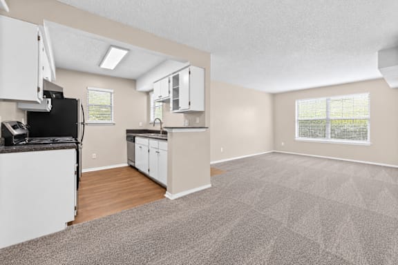 A kitchen area with a refrigerator, microwave, and cabinets.