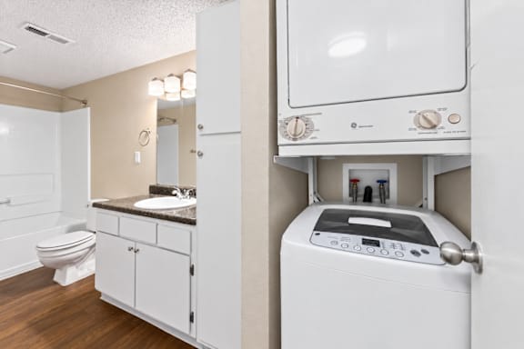 A white washing machine is in a small laundry room.