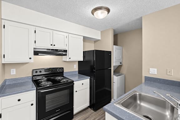 A kitchen with black appliances and white cabinets.