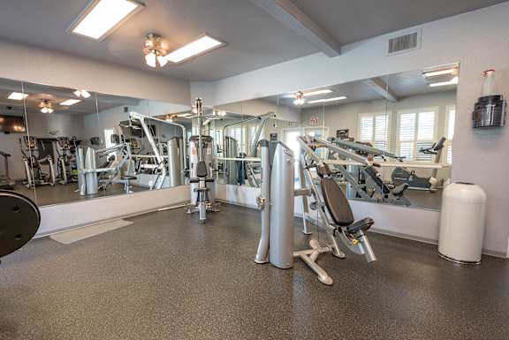 A gym with a variety of equipment including a treadmill, weights, and a bench press at Autumn Oaks Apartments, Roseville, CA, 95678