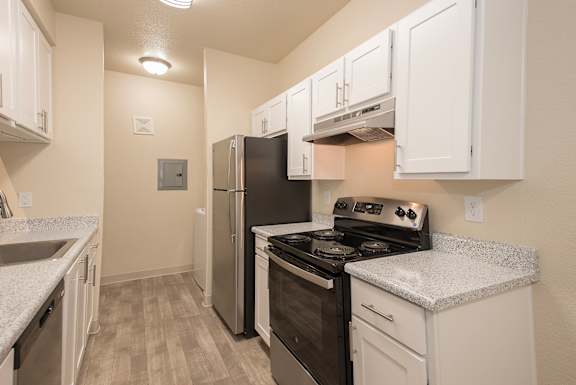 A kitchen with white cabinets and a black refrigerator at Sunset Summit, Rocklin, CA, 95765