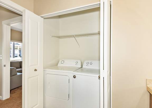 A white laundry room with a washer and dryer at The Landing Apartments and Townhomes, Oregon, 97045