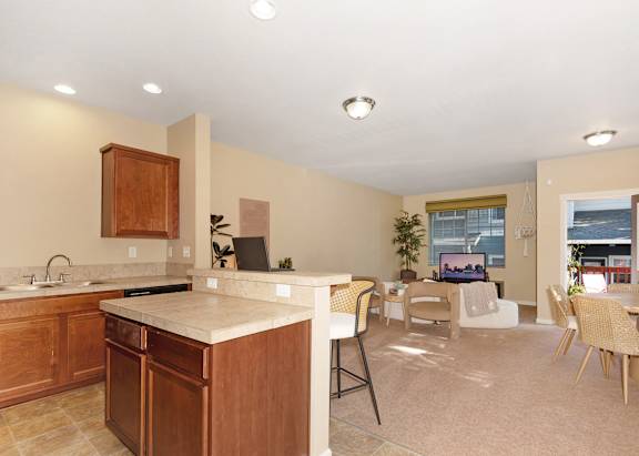 A kitchen with wooden cabinets and a white countertop at The Landing Apartments and Townhomes, Oregon, 97045