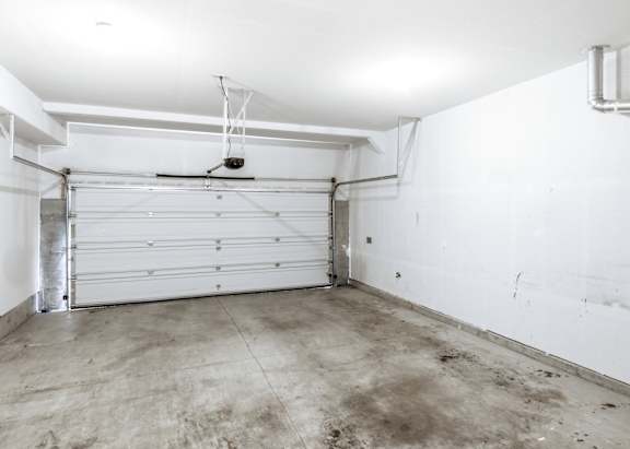 A white garage with a closed white door and a white ceiling at The Landing Apartments and Townhomes, Oregon, 97045
