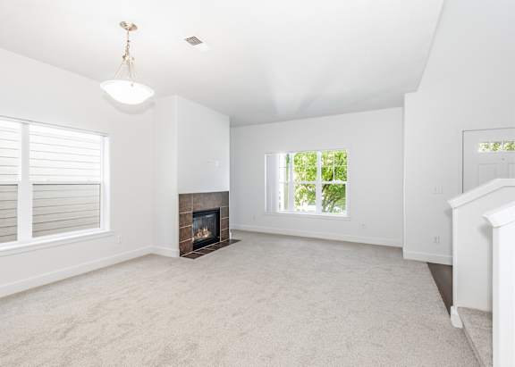 A living room with a fireplace and a window at The Landing Apartments and Townhomes, Oregon, 97045